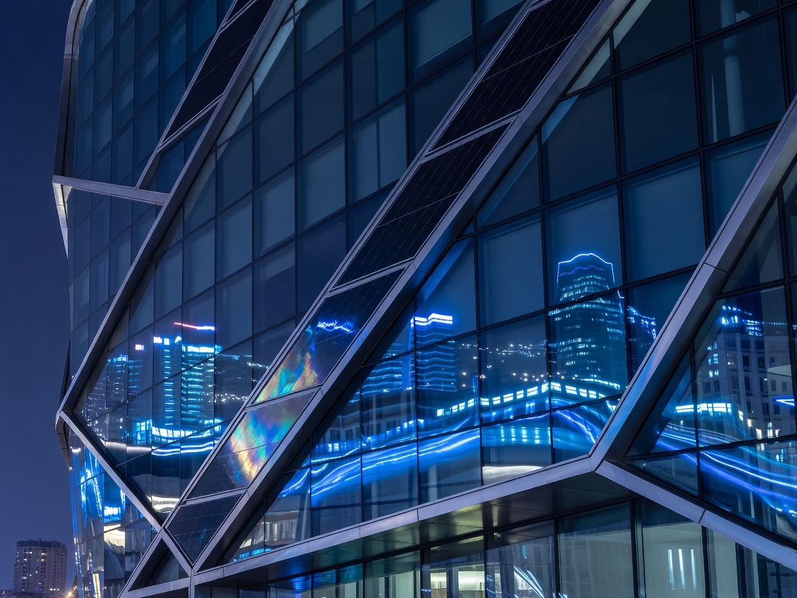 Glass steel facade reflecting electric blue city lights